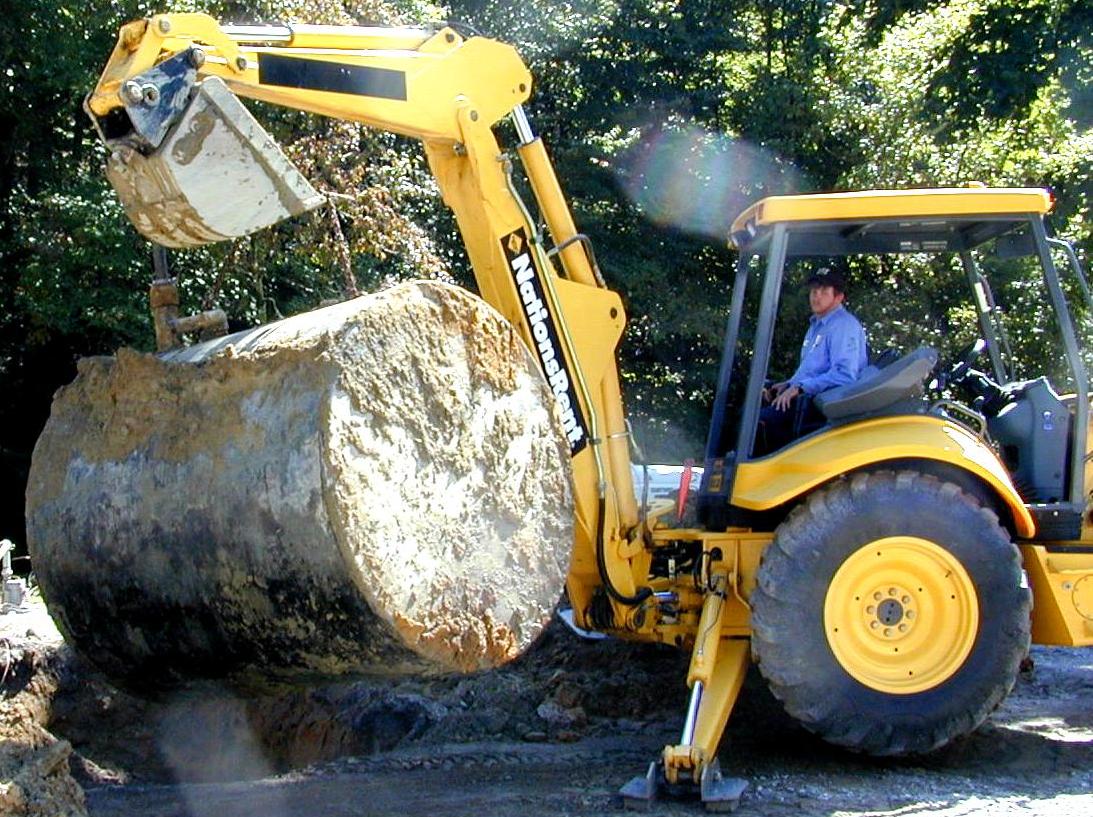 Backhoe removing an underground storage tank