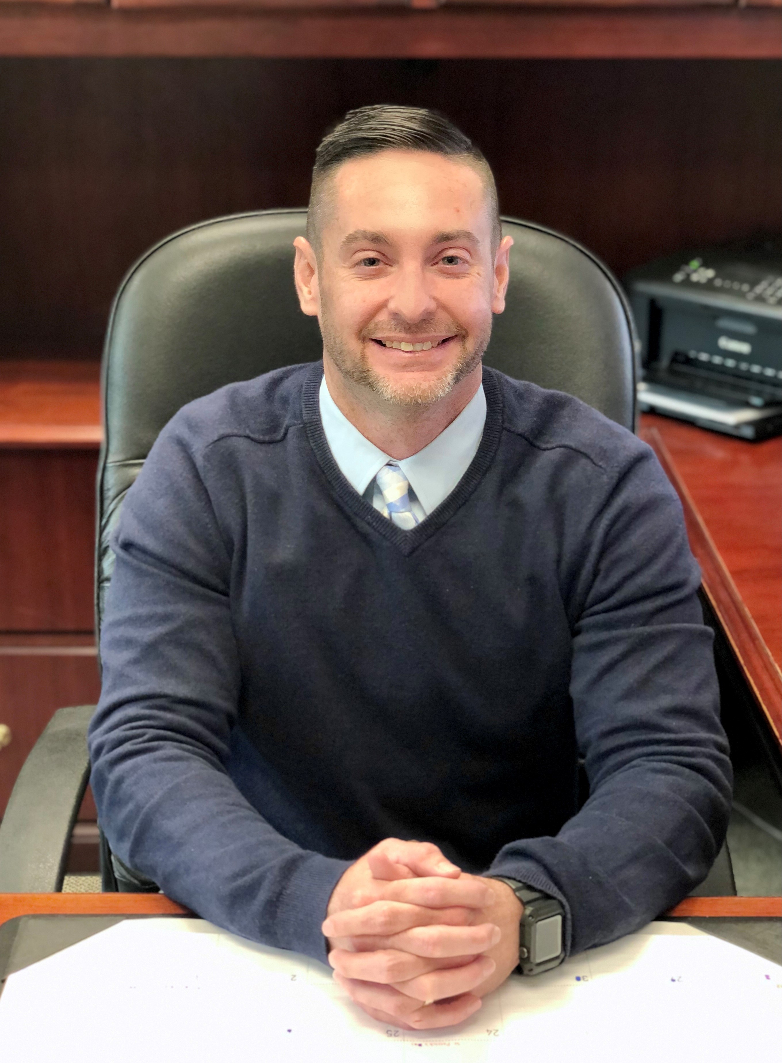 Jonathan Rorrer, DMR Director, sitting at his desk with his hands folded together in front.