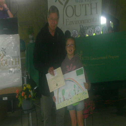 Ed Maguire presenting the Rick Vecellio Memorial Art Poster award to winner Alexandria Johnson.