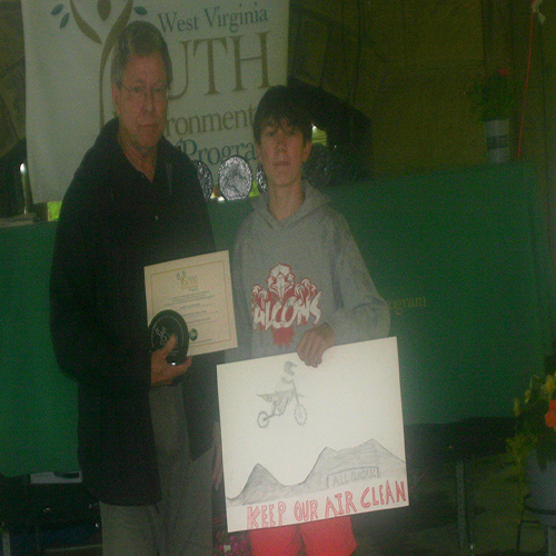 Ed Maguire presenting the Rick Vecellio Memorial Art Poster Contest award to winner Austin Blackshire.