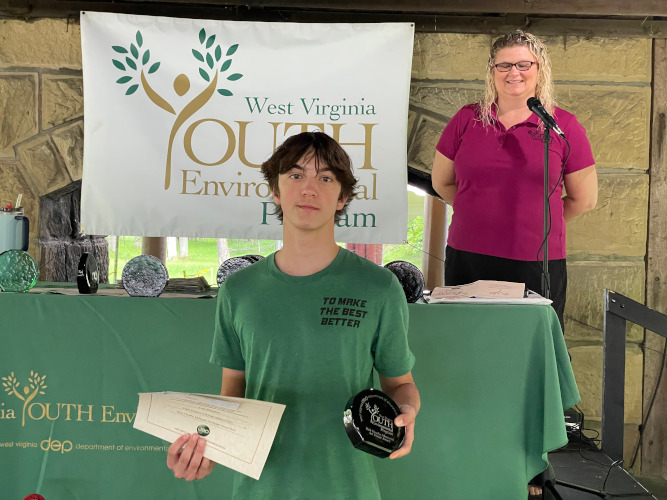 Cade Blackshire, from the Letart Pioneers 4-H Club in Mason County, displays his glass award and certificate for the camera