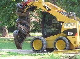 A forklift carrying many old tires that were sent for recycling as part of a tire collection event.